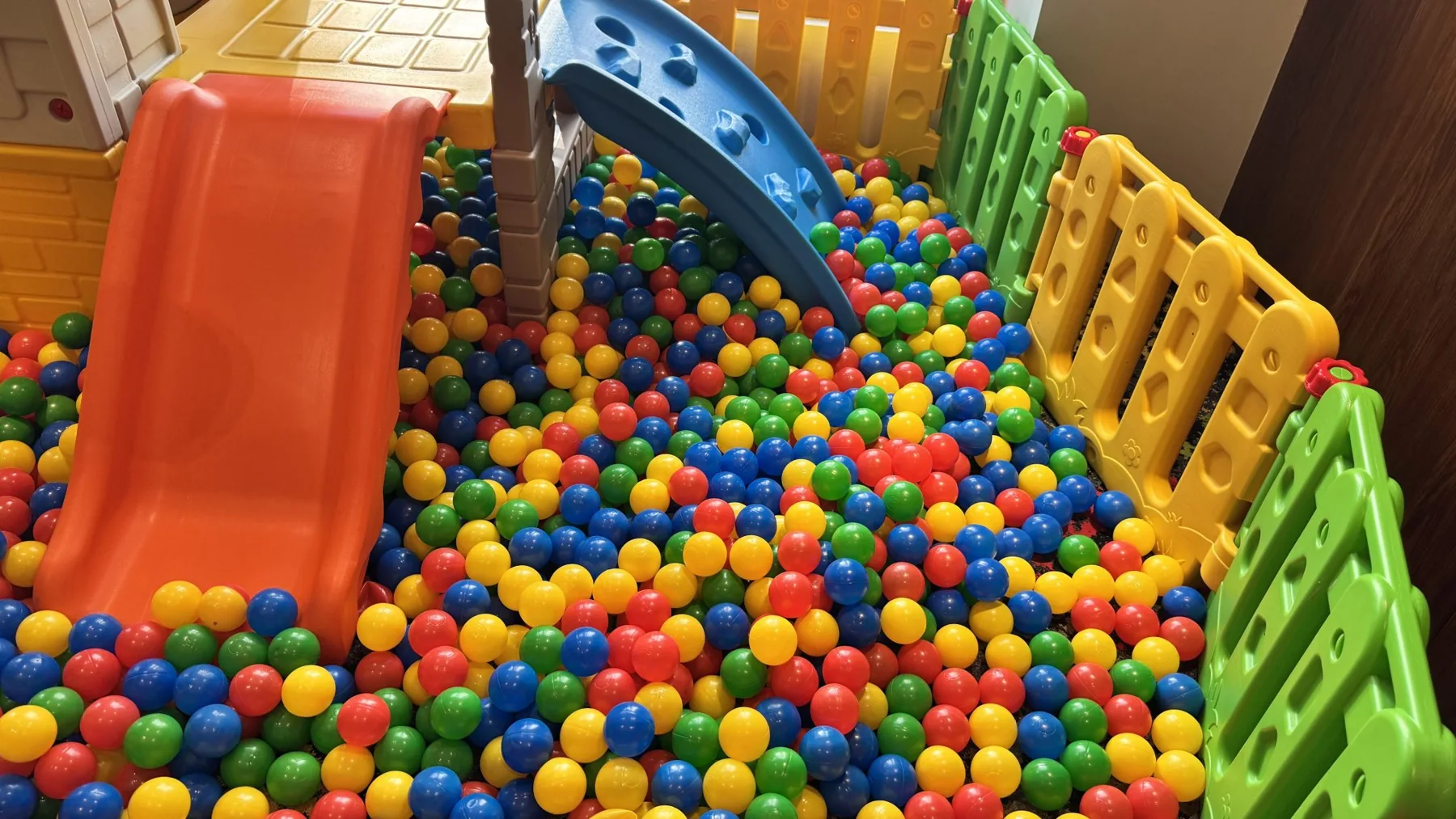 Spielbereich einer Kita mit Bällebad und Rutsche